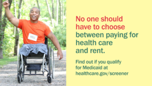A young male leg amputee sitting in a wheelchair, with one fist in the air with message "No one should have to choose between paying for health care and rent."