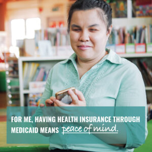 A young blind woman in a classroom, shown using her phone with message "For Me, Having Health Insurance Through Medicaid Means Peace of Mind."